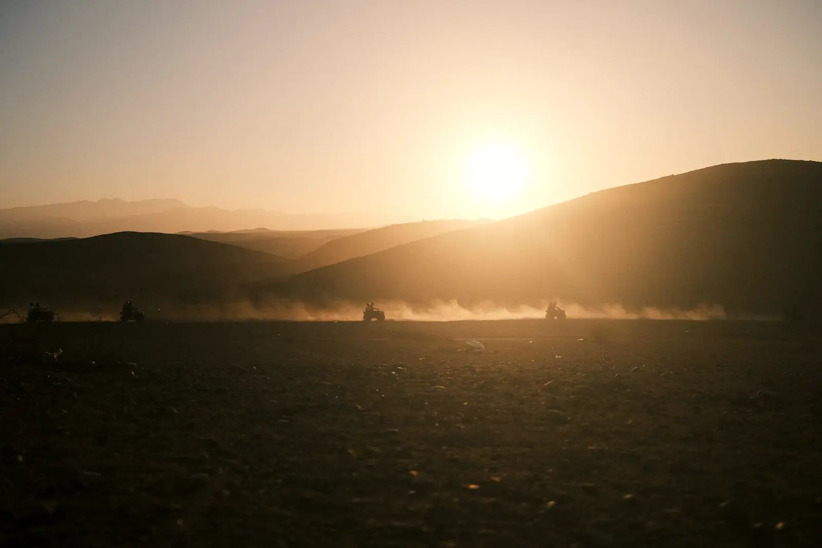 Buggys soulevant la poussière dans le désert au coucher du soleil