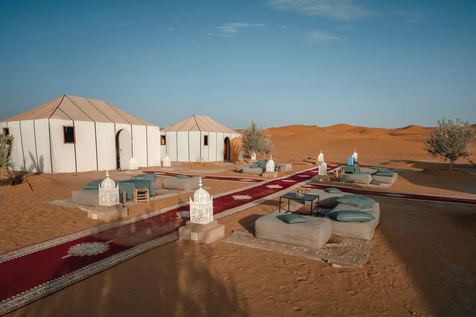 Tentes blanches d’un bivouac au pied des dunes