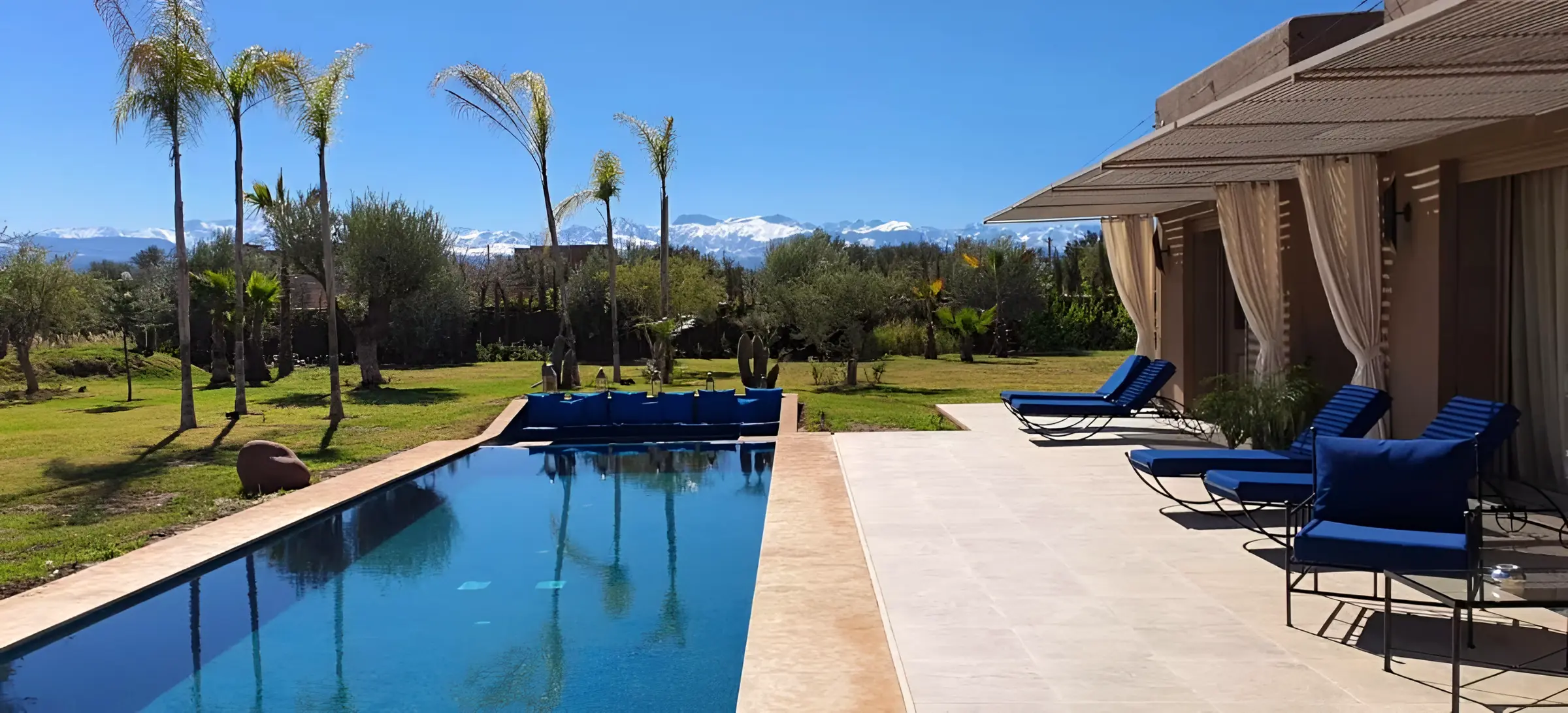 La piscine de la Villa Ma Mounia, ses palmiers et les sommets enneigés de l’Atlas