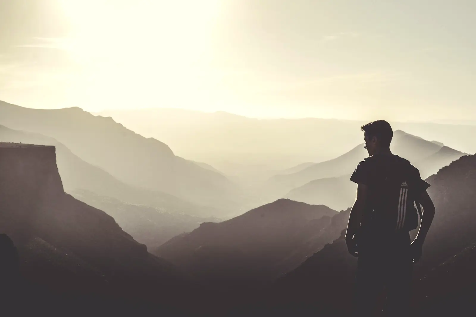 Silhouette d’un marcheur face aux crêtes de l’Anti-Atlas dans la brume