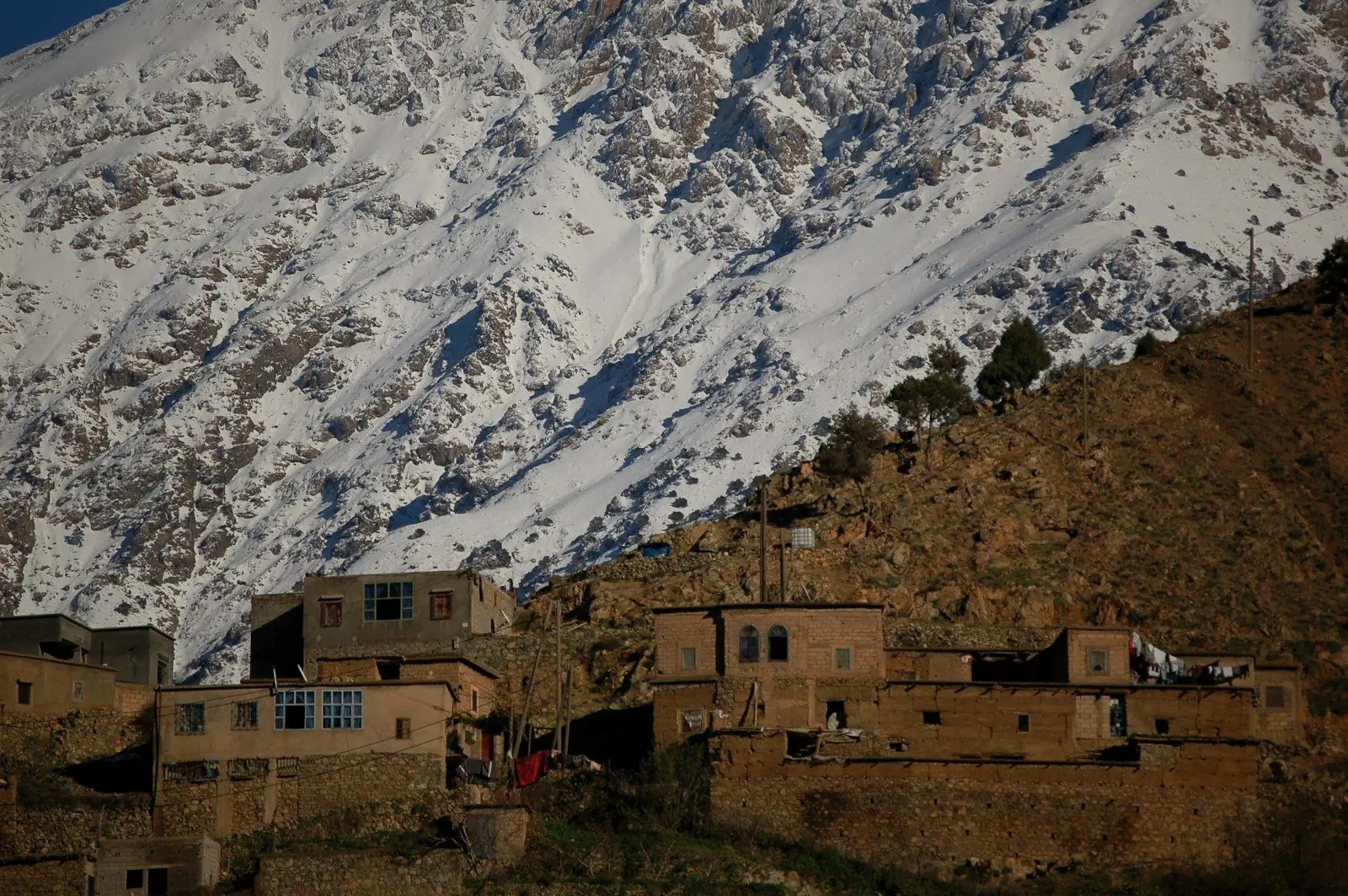 Village berbère au pied d’une montagne enneigée du Haut Atlas